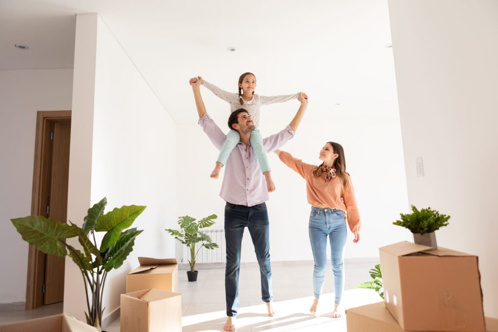 A family unpacking boxes in a bright sunlit Portuguese apartment or house