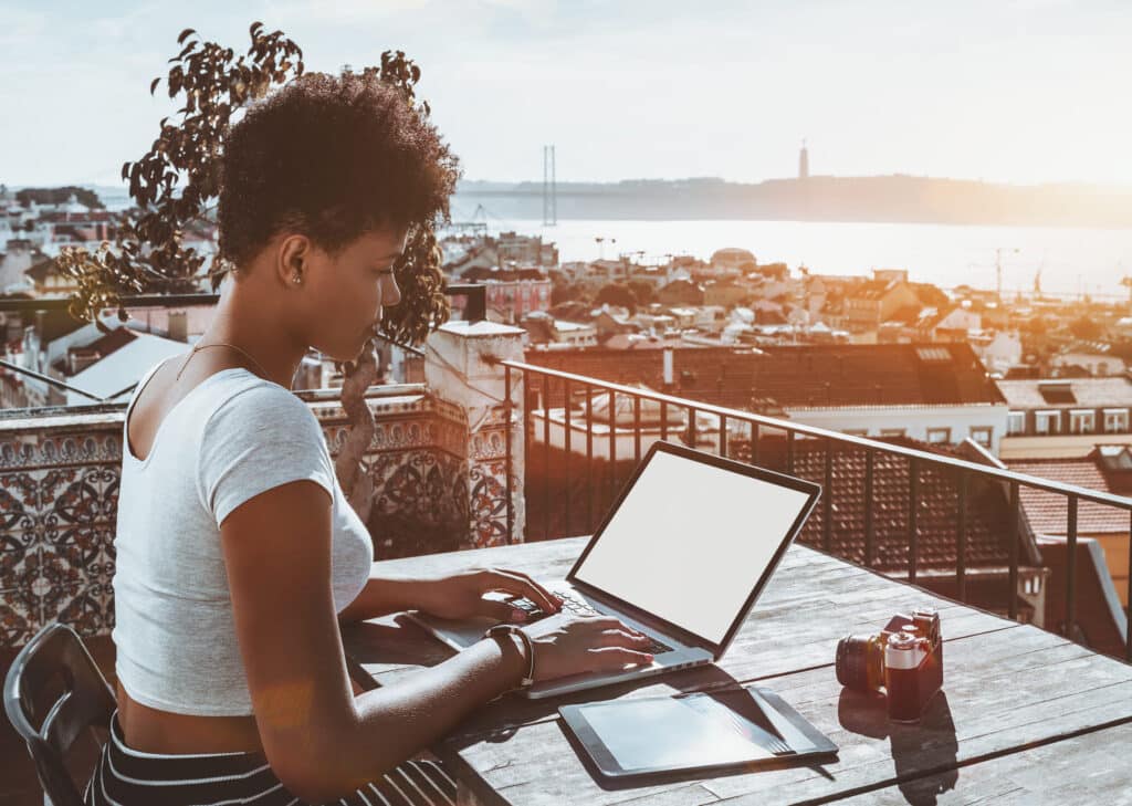 Black curly lady with laptop digital pad and vintage camera in a Lisbon