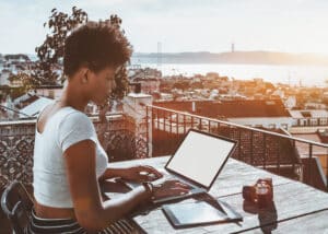 Black curly lady with laptop digital pad and vintage camera in a Lisbon