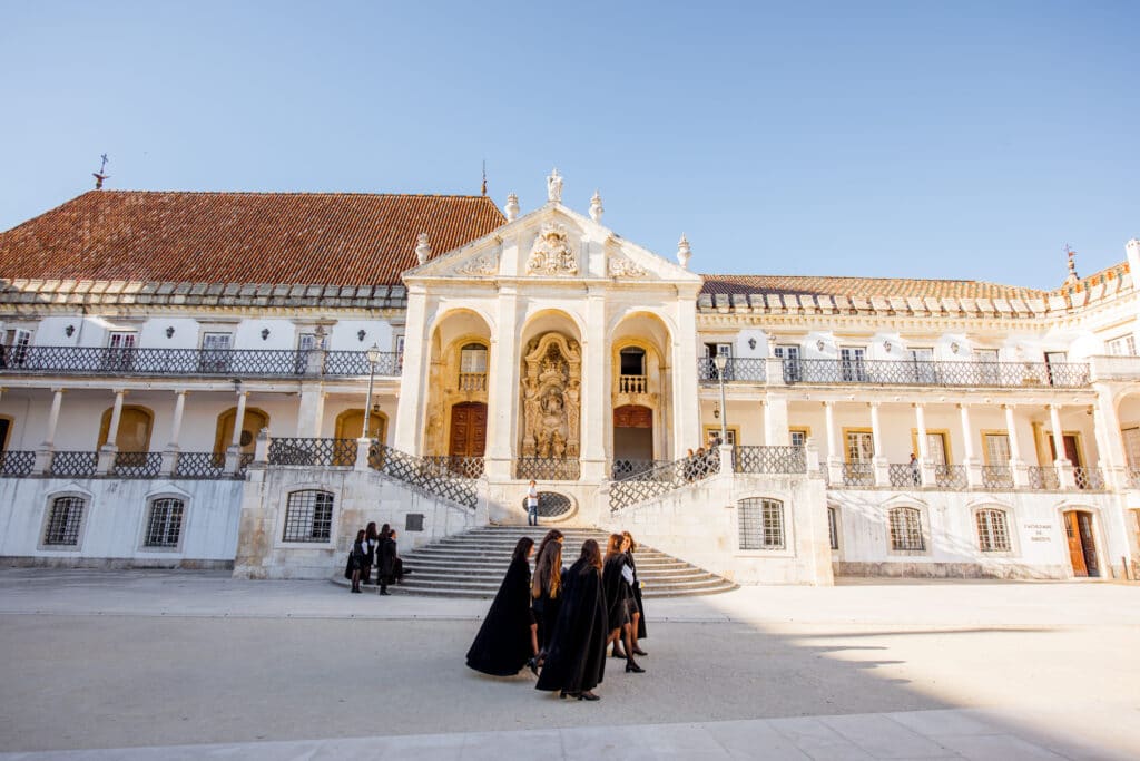Young student walking through Coimbra city in Portugal university courtyard scaled
