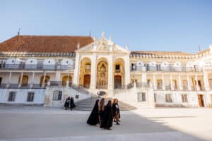 Young student walking through Coimbra city in Portugal university courtyard scaled
